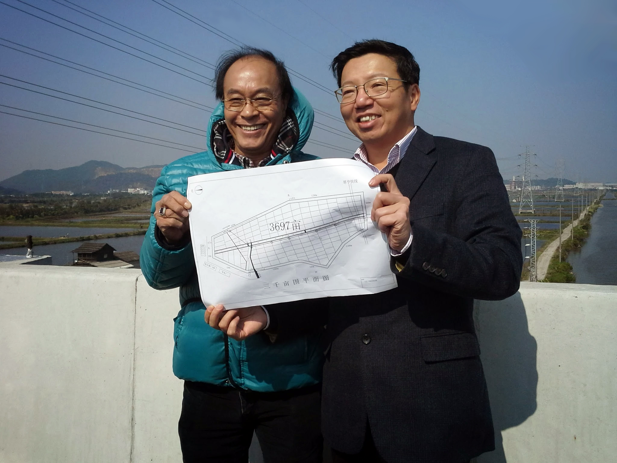 Solomon Lee and Deputy Mayor Xie holding plan of Zhongshan Prawn Project